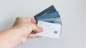 A person holding 4 credit cards