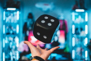 Person's hand catching a black dice